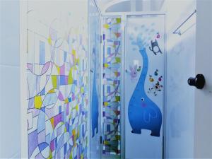 a bathroom with a shower with a mural of a cat at Work Life Balance Busan Station in Busan +37 photos