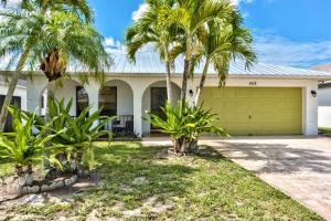 a house with palm trees in front of it at Avanti Vacation Rental in Naples