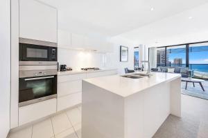 a kitchen with white cabinets and a view of the ocean at Oracle-Awesome Ocean Views in Gold Coast