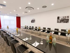 une salle de conférence avec une grande table et des chaises dans l'établissement DORMERO Hotel Roth, à Roth