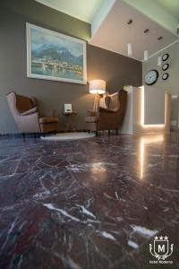 a living room with chairs and a marble floor at Hotel Moderno in Lecco