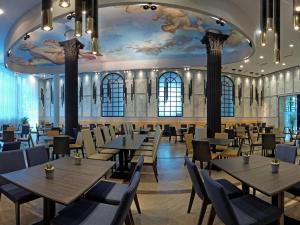 ein Restaurant mit Tischen und Stühlen und einer Decke mit Wandmalereien in der Unterkunft Astera Hotel & Spa with FREE PRIVATE BEACH in Goldstrand