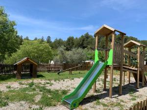 a playground with a green slide in a yard at Camping Manaysse in Moustiers-Sainte-Marie
