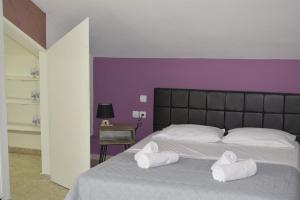 een slaapkamer met een groot bed en 2 handdoeken bij Dimitra Boutique Apartments 1 in Keramotí