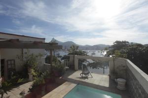 a balcony of a house with a view of the water at Hotelinho Urca Guest House in Rio de Janeiro