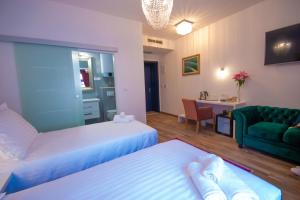une chambre d'hôtel avec deux lits et un canapé vert dans l'établissement Center Luxury Rooms 2, à Split