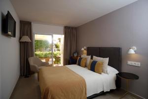 a bedroom with a large bed with yellow and blue pillows at miKasa Agua Amarga & SPA in Agua Amarga