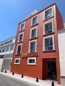 a red building with a sign on it at Suites André Confort Ejecutivo in Aguascalientes