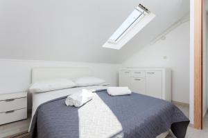 1 dormitorio con 1 cama con 2 toallas en Villa Barbara - Olive Paradise, with chlorine-free pool en Vela Luka