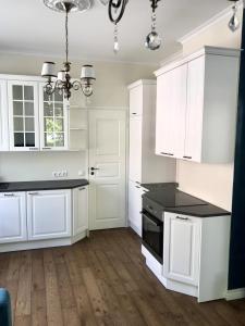 uma cozinha com armários brancos e um balcão preto em Lahe 9 - apartement in Haapsalu Old Town em Haapsalu