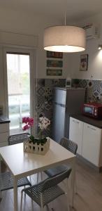 een keuken met een witte tafel en stoelen en een tafel met bloemen bij CASA FLORA in Palermo