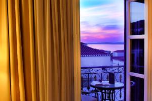 a view from a window of a balcony with a sunset at Armata Boutique Hotel in Spetses