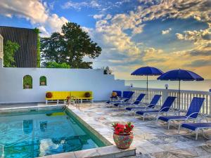 una piscina con sedie e ombrelloni blu di Hotel Tramonto a Chakvi