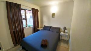 a bedroom with a blue bed and a window at Blouberg Beach Retreat in Bloubergstrand