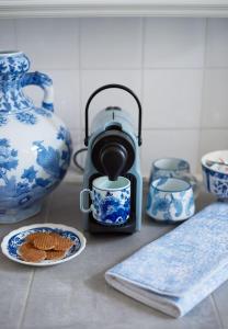 a tea kettle with a cup and some blue and white vases at Vondelpark House B&B in Amsterdam