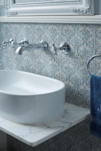 a bathroom with a white sink and blue wallpaper at Vondelpark House B&B in Amsterdam