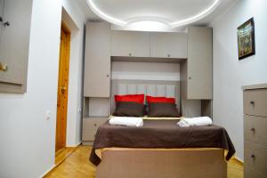 sypialnia z dużym łóżkiem z czerwonymi poduszkami w obiekcie Anastasia Apartment w Kutaisi