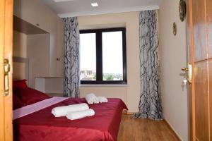 a bedroom with two towels on a bed with a window at Anastasia Apartment in Kutaisi