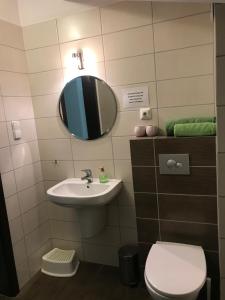 a bathroom with a sink and a toilet and a mirror at Apartament Limonka in Władysławowo