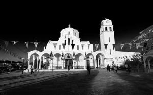 a large white building with a clock tower at night at Nana Hotel in Kamena Vourla