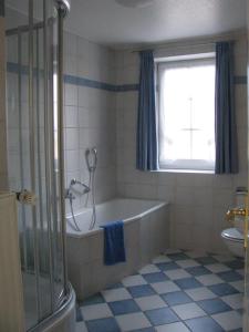 Haushälfte Luv und Lee في تاتينغ: حمام مع حوض استحمام ونافذة