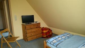 a bedroom with a bed and a television on a dresser at Ferienwohnungen Meeresgruss in Sankt Peter-Ording