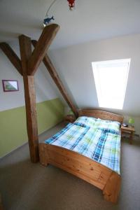 ein Schlafzimmer mit einem Holzbett in einem Zimmer in der Unterkunft Ferienhof Röhe in Tümlauer Koog