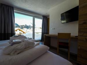 Habitación de hotel con cama y ventana grande en Collina Hotel Garni, en Nauders