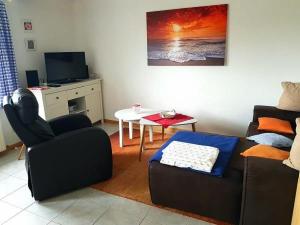 una sala de estar con un sofá y una mesa en Landhaus op de Warft, en Vollerwiek