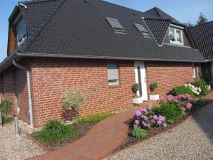 a red brick house with a brick walkway at Strandgut-Tating in Tating