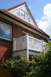 a house with a balcony on top of it at Ferienwohnung am Seezeichen in Böhl +6 photos