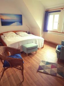 sypialnia z łóżkiem, krzesłem i dywanem w obiekcie Landhaus op de Warft w mieście Vollerwiek