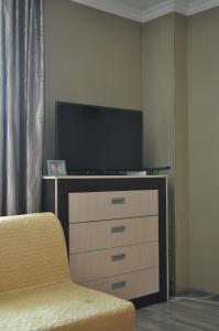 sala de estar con TV y tocador en Zhenis street, en Astana