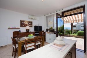 een keuken en eetkamer met een tafel en stoelen bij Apartments Zeljko in Lovran