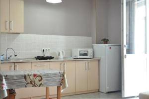 Una cocina con un refrigerador blanco y una mesa. en Zhenis street, en Astana