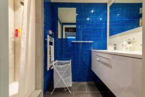 達默的住宿－De gouden Kop 2 Vakantiestudio Centrum Damme，蓝色瓷砖浴室设有水槽和淋浴