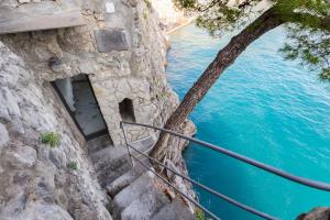 a set of stairs next to a body of water at Torre Silja in Positano