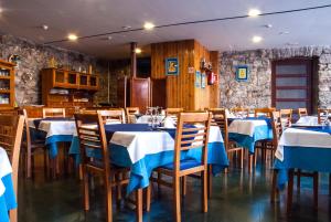 Balneario Caldas de Luna في Caldas de Luna: مطعم بطاولات وكراسي زرقاء وبيضاء
