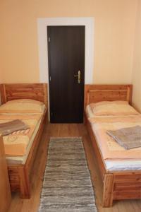 a bedroom with two beds and a wooden floor at Penzion Javorina in Čičmany