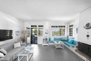 a living room with blue couches andwindows at Vourvourou Villa Mare Verde by Luxlikehome in Vourvourou