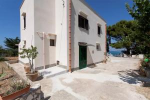 een klein wit gebouw met een groene deur bij Villetta - Panorama da Sogno [Wi-Fi Gratis] in Castellammare del Golfo