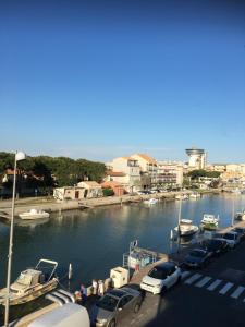 a marina with parked cars and boats in the water at appartement atypique en duplex in Palavas-les-Flots
