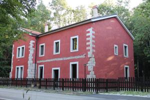 een rood gebouw met een hek ervoor bij Cantoniera D'Umbra Agriturismo in Vico del Gargano