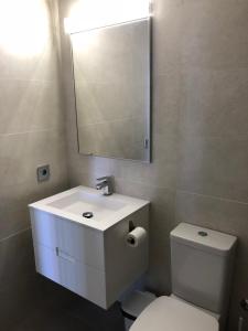 a bathroom with a sink and a toilet and a mirror at Vistabella Golf Bali 11 in Vistabella +29 photos