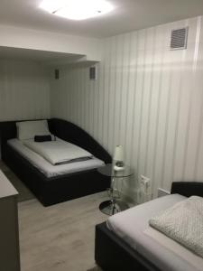 una camera da letto con due letti e un tavolo di Varkerulet Apartman a Sárvár