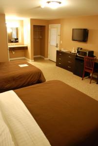 a hotel room with two beds and a flat screen tv at Abbot Trailside Lodging in Abbot Village
