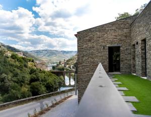 a stone building with a pathway leading up to a door at Dois Lagares House in Pinhão