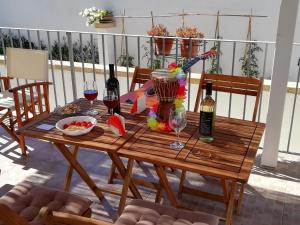 un tavolo in legno con 2 bottiglie di vino e bicchieri di Xenios Torre Suda a Torre Suda
