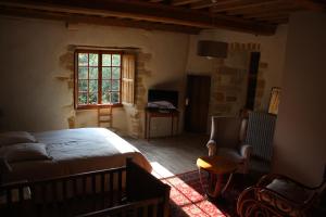- une chambre avec un lit, une chaise et une fenêtre dans l'établissement Manoir de la Ventinière, à Marchésieux