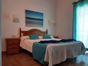 um quarto com uma cama com toalhas azuis em Apartamentos Marivent em Cala en Blanes